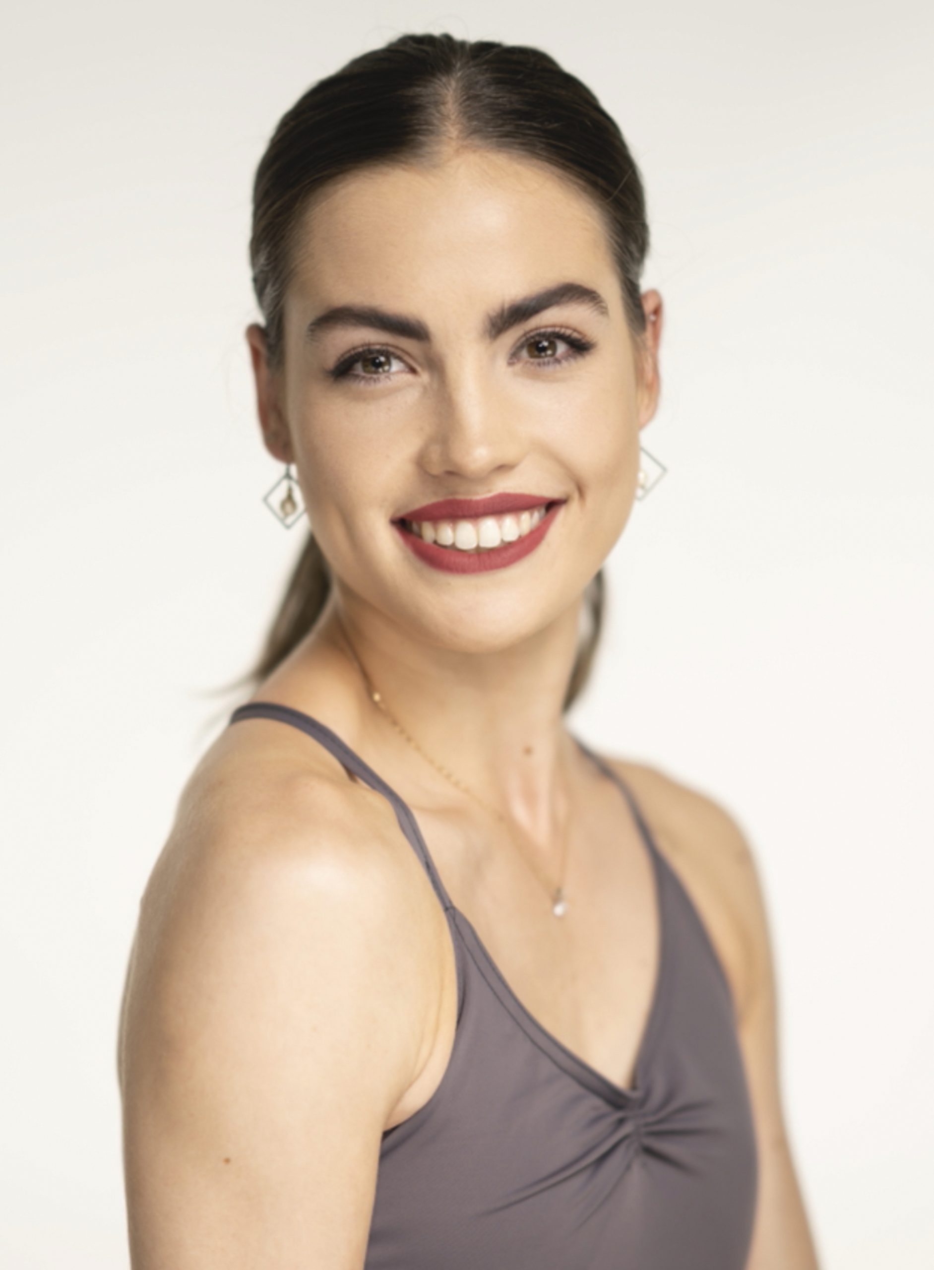a woman in a tank top smiling at the camera