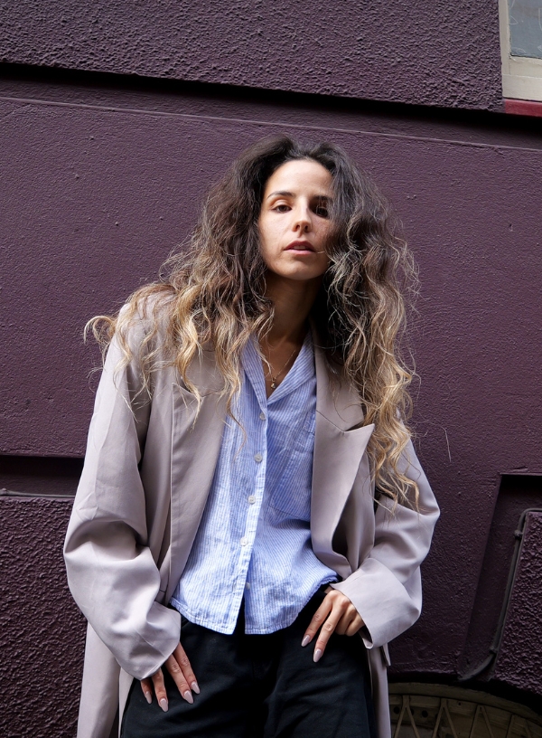 a woman standing in front of a purple wall