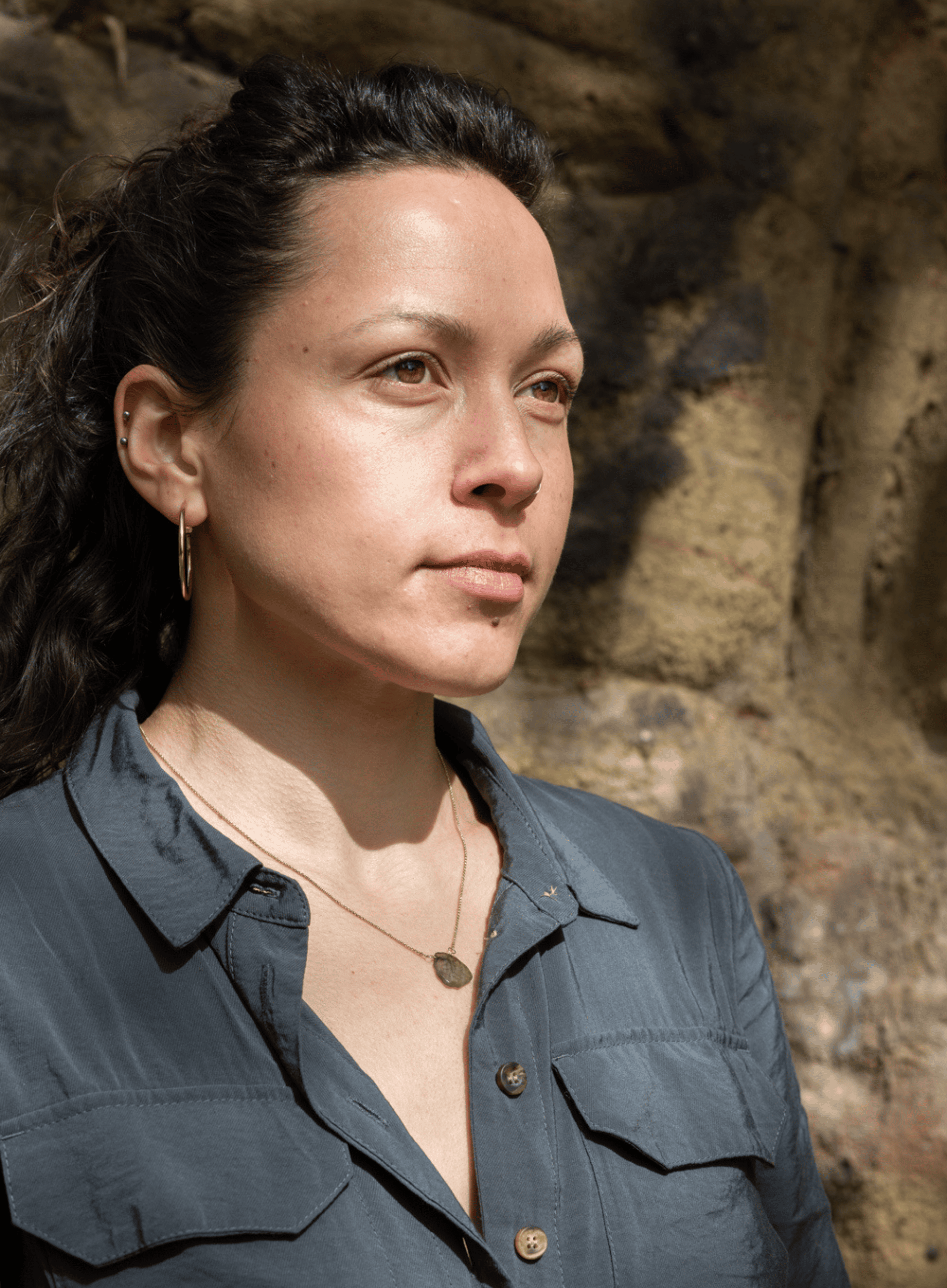 Headshot of Sophie Thorpe, a fair skinned woman in her 30s with dark hair tied up, wearing a dark coloured shirt and gold jewellery.